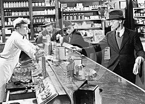 Four men at a soda fountain