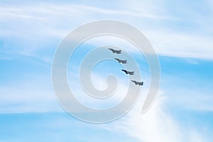 Four military fighter aircrafts in cloudy sky