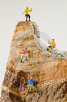 Miniature climbers climbing rocks photo