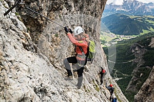 Four mountain climbers on a Via Ferrata in the Dolomites in Alta Badia