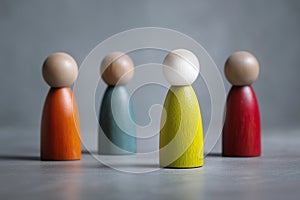 Four Multicolored Wooden Figurines on Gray Surface with Highlighted Central Figure â Symbol of Diversity and Individuality photo
