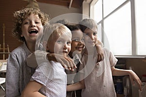 Four multiethnic children laughing staring at camera