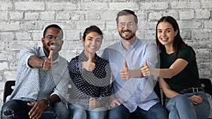 Four multiethnic persons job seekers showing thumbs up being hired