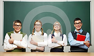 Four nerds holding books