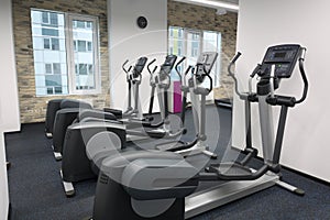 Four new elliptical trainers in modern empty hall photo