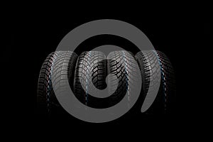 Four new tires isolated on black background