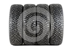 Four new winter car tires with spikes on a white background. Isolated