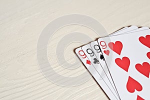 four nine poker hands playing cards on a light desk background.