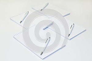 Four notepads with pens on white background. empty copy space. Mockup.