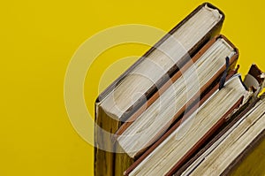 Four old diaries standing on endpaper on yellow background