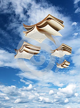 Four open books flying above