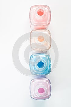 Four open bottles of pastel-colored nail polish in a row.