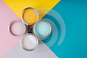 Four open cans of paint on bright symmetry background.