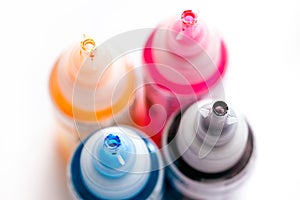 Four open printer bottles with CMYK colour ink