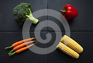 Four organic vegetables on slate plate