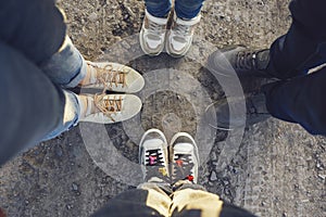 Four pairs of feet of family standing together on ground road. Selfie of four couples legs woman, child, man and tenager