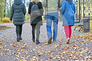 Four pairs of legs male and female go on autumn leaves