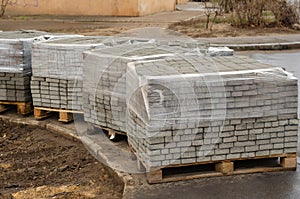 Four pallets with new paving tiles.