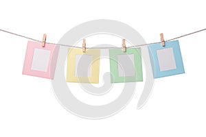 Four paper photo frames hanging on the rope isolated on white background