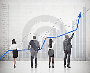 Four people holding a graph