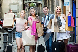 Four people holding paper bags