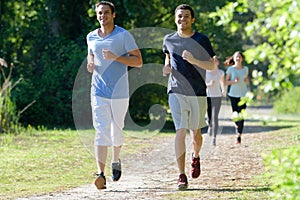 four people jogging two men in front two women behind