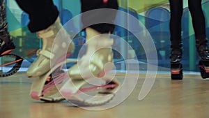 Four people jumping in kangoo shoes in the gym.