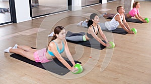 Four people lying in cobra pose with bender balls