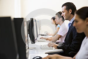 Four people sitting in computer room typing