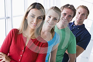 Four people standing in corridor smiling