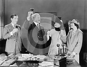 Four people toasting with wine