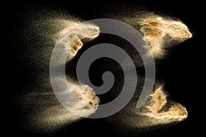 Four photos of sand explosion isolated on black background. Freeze motion of sandy dust splashing