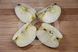 Four pieces of apple on wooden background