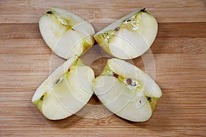 Four pieces of apple on wooden background