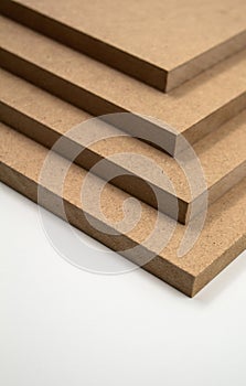 Four plates of raw MDF stacked on top of each other, on a white background.