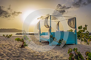 Four poster bed on the beach at sunset