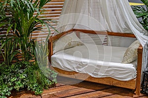 Four-poster bed on a wooden porch