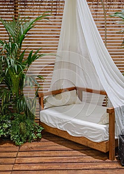 Four-poster bed on a wooden porch