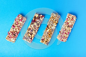 Four protein bars with cereals isolated on blue background, a copy of the space