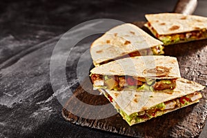 Four quesadilla pieces on dark background