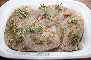 Four raw split chicken breast in slow cooker with seasoning