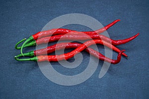 Four red chili pepper isolated on a black background