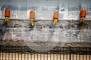 Four red Chinese lanterns against a mottled wall