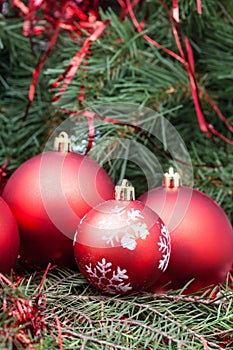 Four red Christmas balls and Xmas tree background