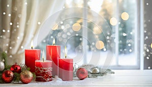 Four red Christmas candles on a table by winter view window