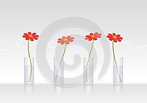 Four red daisies in glass vases