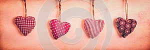 Four red fabric hearts on vintage panoramic background