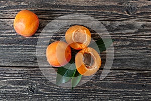 Four ripe apricots on a wooden table. Rough wooden table. Bright