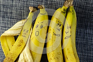 Four ripe bananas with faces. Love, relationships, family concept
