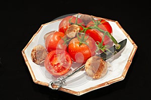 Four, ripe, red, field ripe, stemed, tomatoes and four shitaki mushrooms on white plate